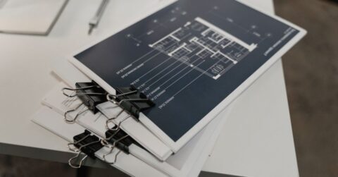 기계 설계 도면과 볼트 너트 체결 부품을 검토하는 엔지니어의 모습